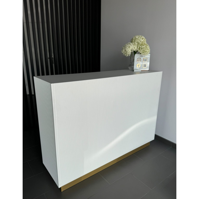 Eine stilvolle Empfangstheke für das Wohnzimmer – Empfangsmöbel mit geriffelter Front in Beige und goldenen Akzenten. Eine stilvolle Empfangstheke für das Wohnzimmer – Empfangsmöbel mit geriffelter Front in Beige und goldenen Akzenten.