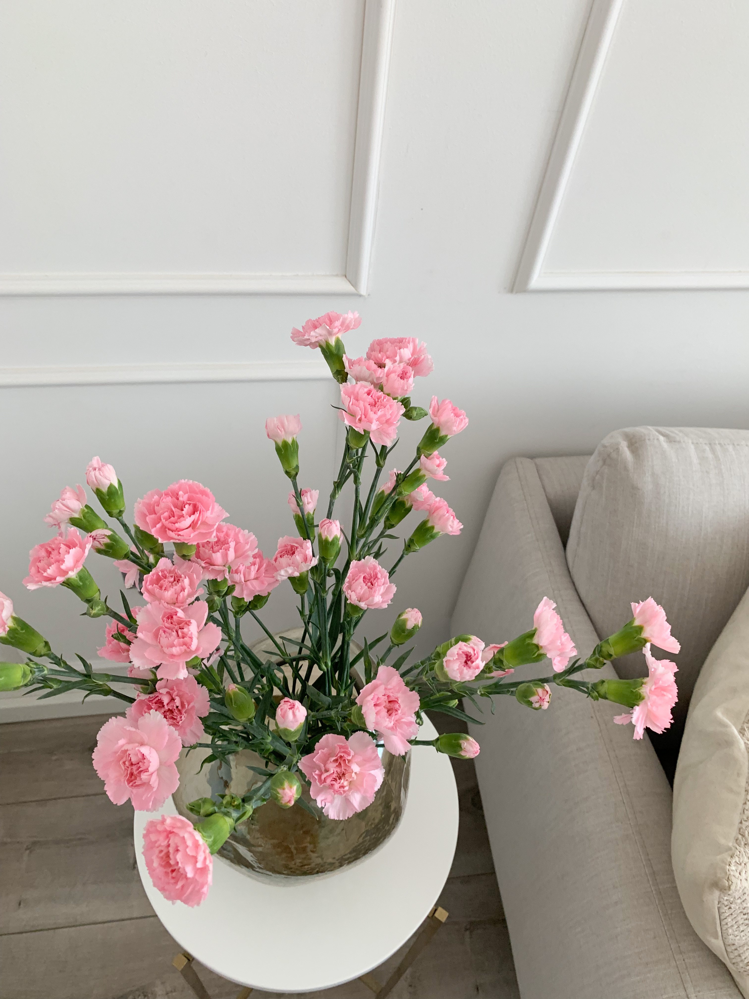 Ein kleiner runder Tisch mit Blumen – moderne Einrichtungsaccessoires